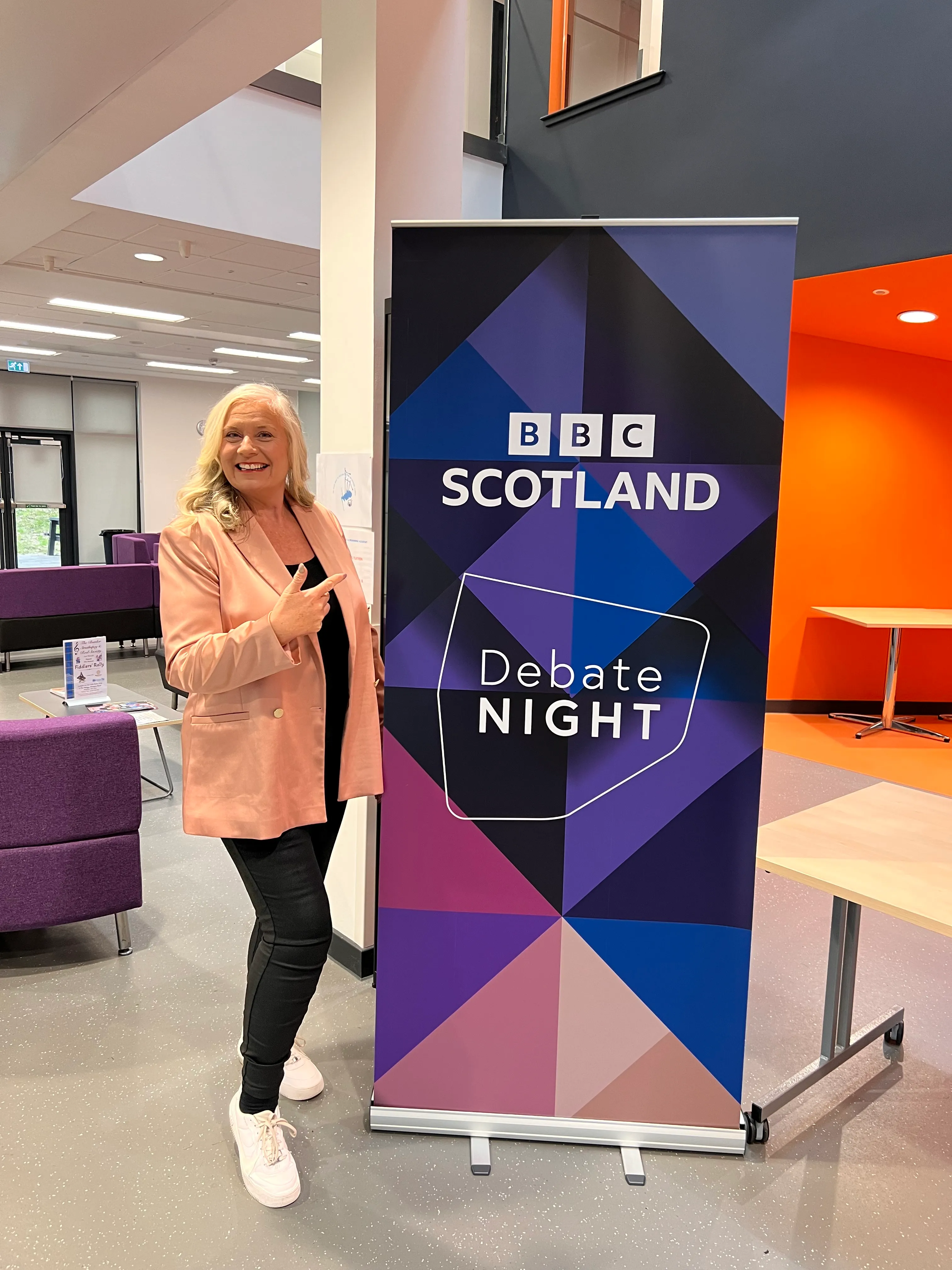 Alison pointing at the BBC Scotland Debate Night banner backstage before the programme.