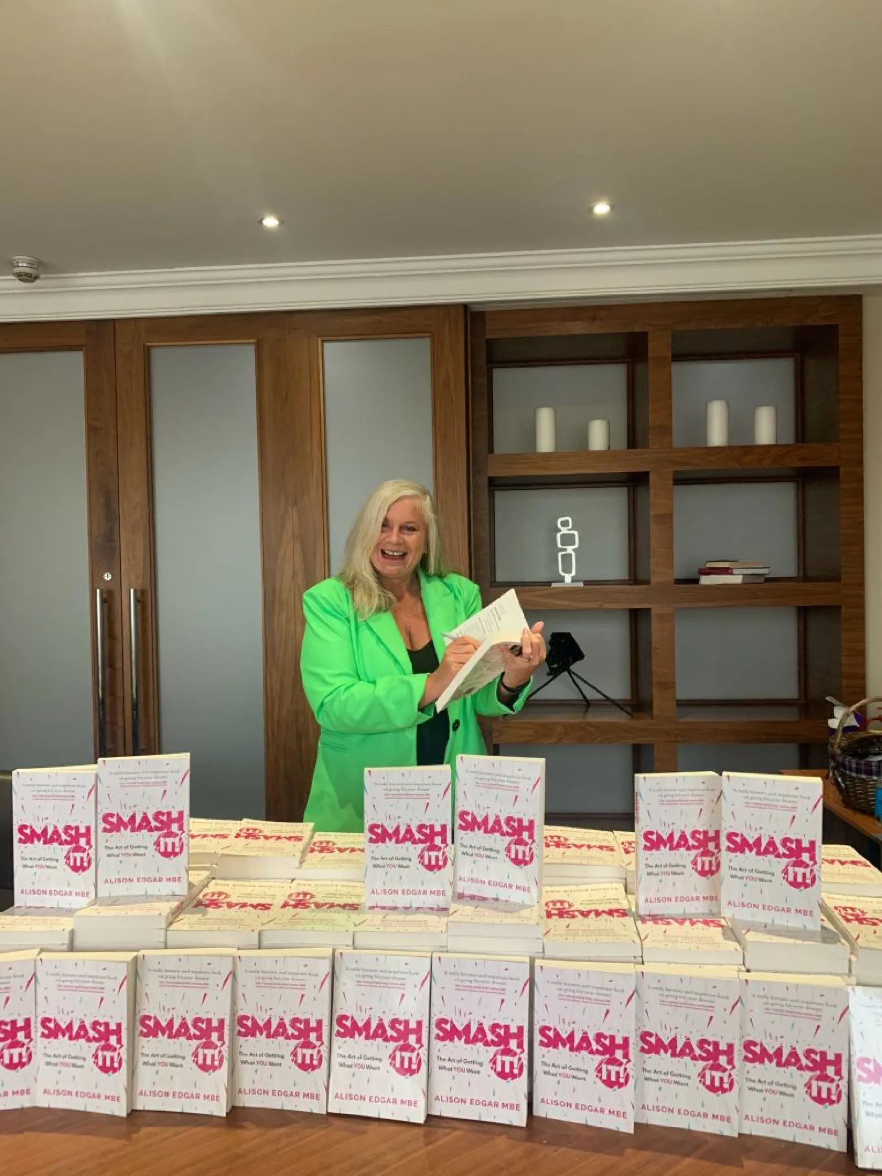 Alison signing her way through a table stacked high with copies of SMASH IT!