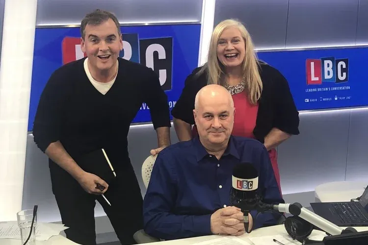 Alison in the LBC studio with the presenters, behind the microphone desk.