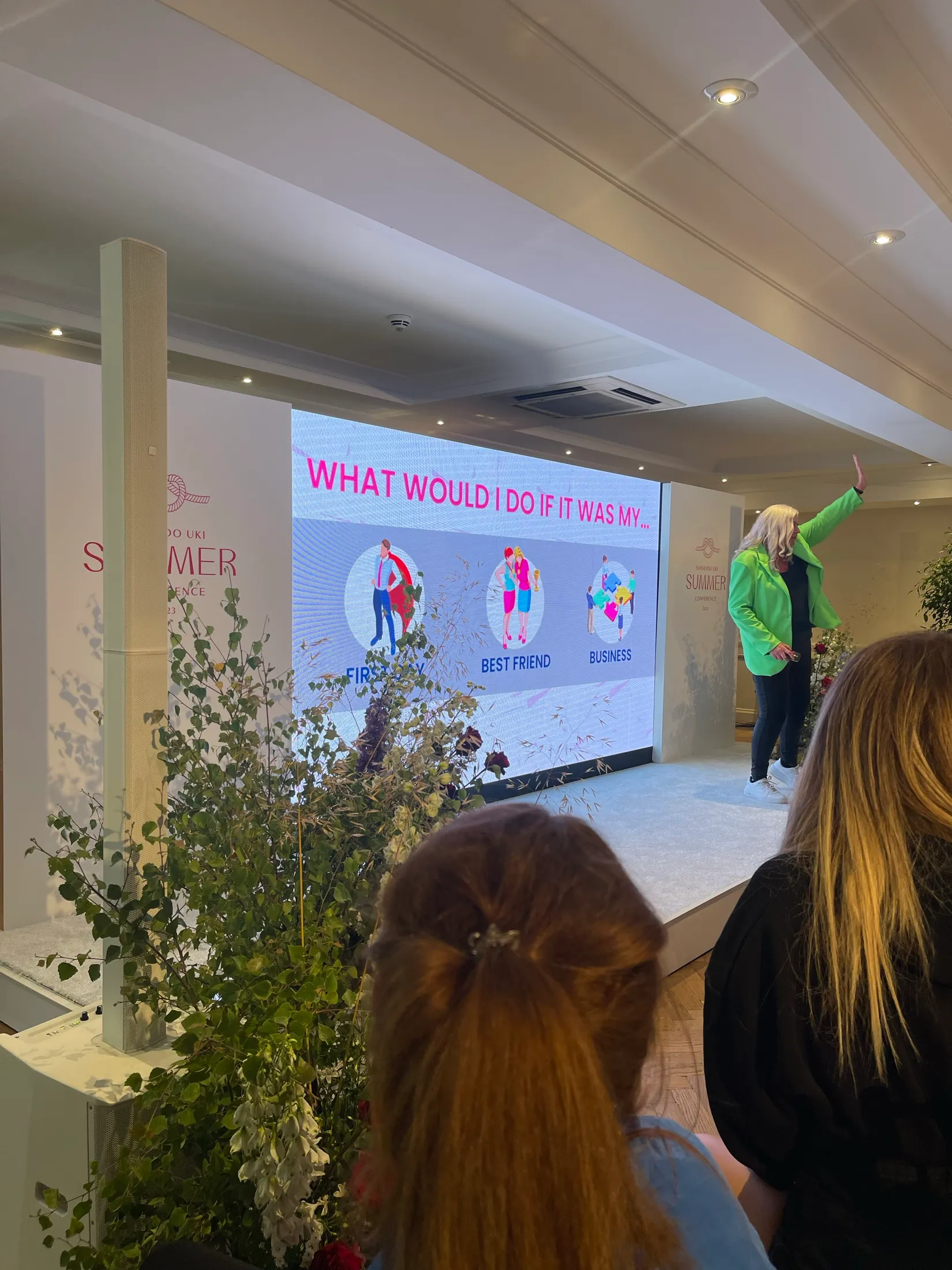 Alison on stage with her framework's question filling the screen, asking what would I do if it was my first day, best friend or business.